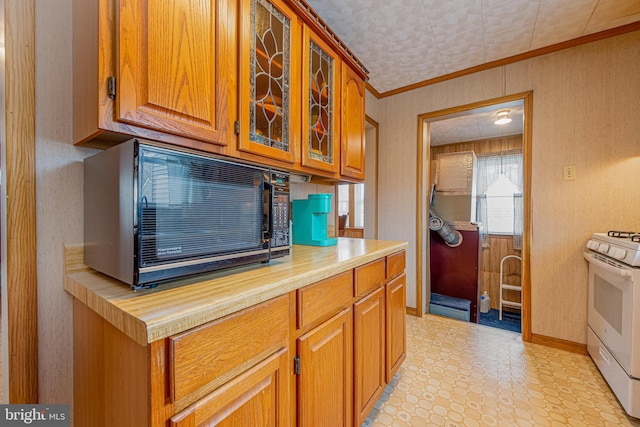 kitchen with crown molding and white gas stove