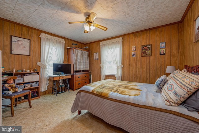 bedroom featuring multiple windows, ceiling fan, light carpet, and wood walls