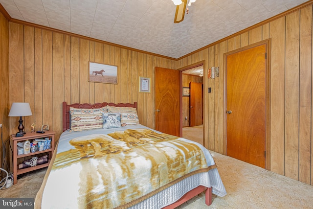 bedroom with ceiling fan, ornamental molding, carpet floors, and wood walls