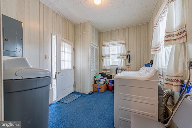 laundry room featuring separate washer and dryer, wooden walls, electric panel, and carpet flooring