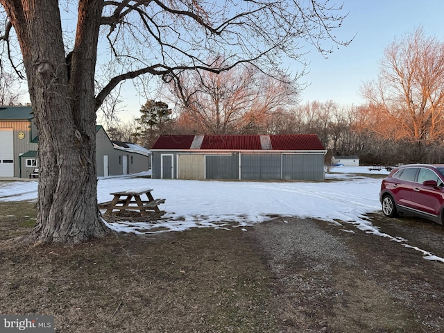 yard layered in snow featuring an outbuilding