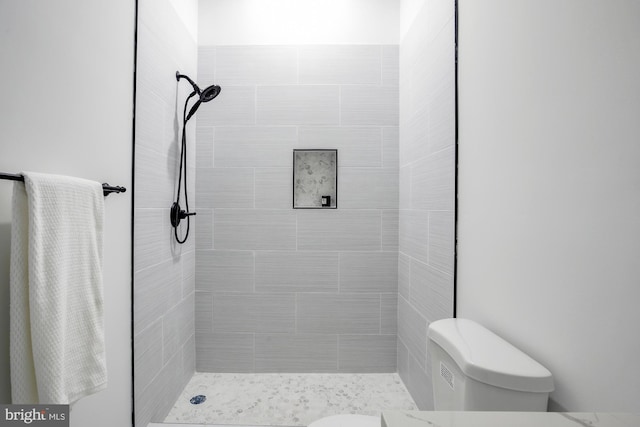 bathroom featuring toilet and tiled shower