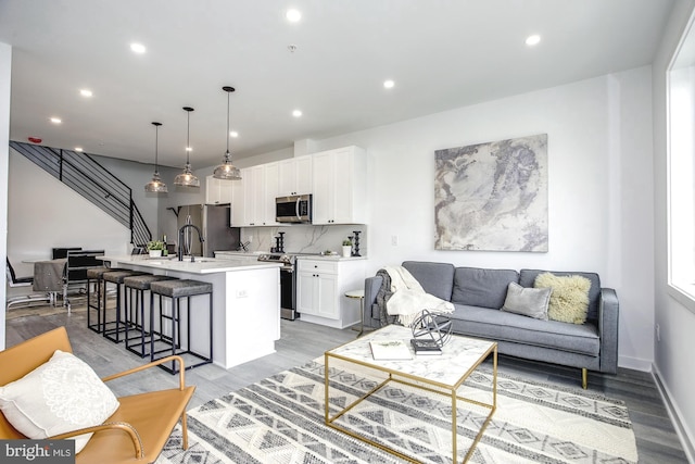 living room with sink and light hardwood / wood-style flooring