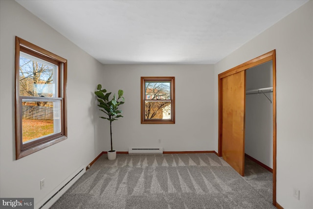 unfurnished bedroom with multiple windows, a baseboard radiator, and carpet