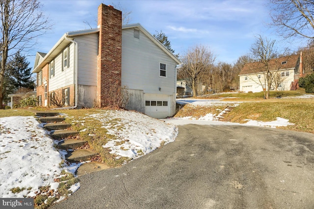 view of snow covered exterior featuring a garage