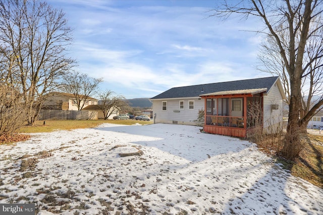 view of snow covered back of property