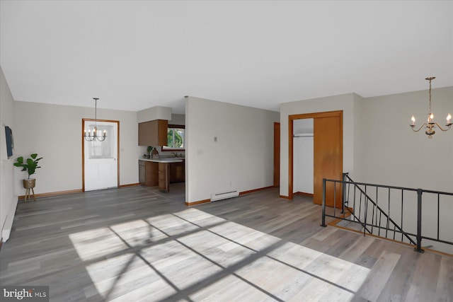 interior space featuring a notable chandelier, light hardwood / wood-style floors, a baseboard radiator, and sink