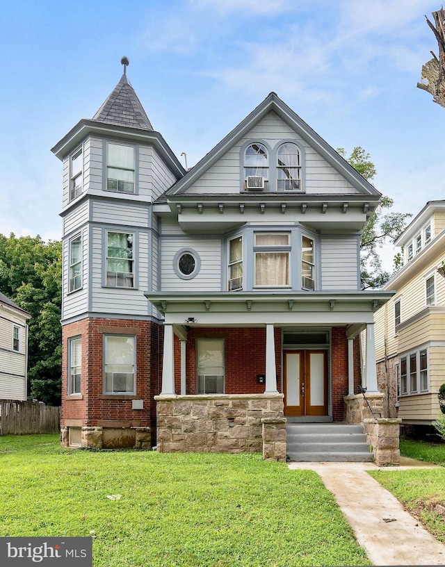 victorian house with a front yard and covered porch