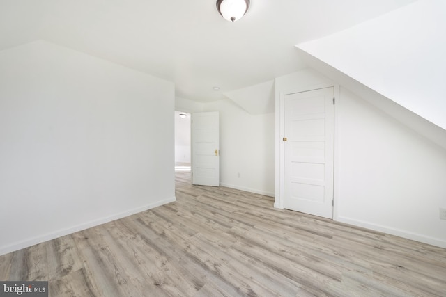 bonus room featuring light wood-type flooring and vaulted ceiling