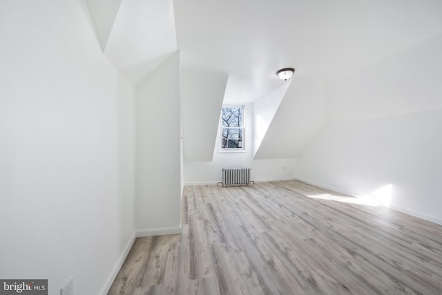 bonus room with light hardwood / wood-style flooring, radiator heating unit, and vaulted ceiling