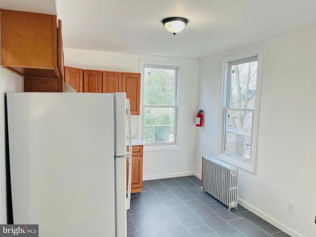 kitchen with radiator heating unit and white fridge