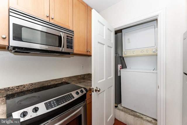 kitchen featuring stainless steel appliances and stacked washer / dryer