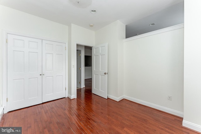 unfurnished bedroom featuring a closet and dark hardwood / wood-style floors