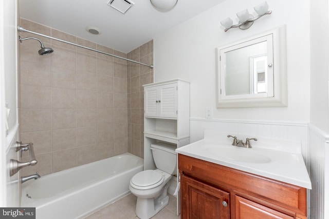 full bathroom featuring toilet, vanity, tiled shower / bath, and tile patterned flooring