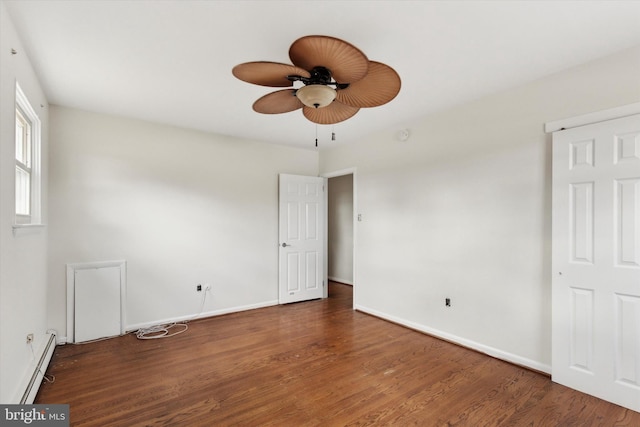 empty room with a baseboard heating unit, ceiling fan, and dark wood-type flooring