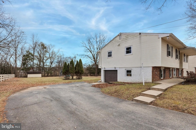 view of side of property featuring a garage and a lawn