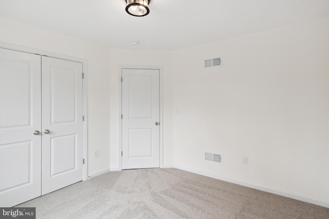 unfurnished bedroom with a closet and light carpet