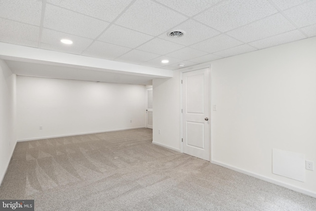 basement with light colored carpet and a drop ceiling