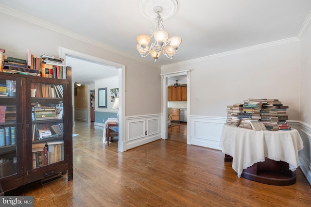 dining area featuring wood-type flooring, ornamental molding, and a chandelier