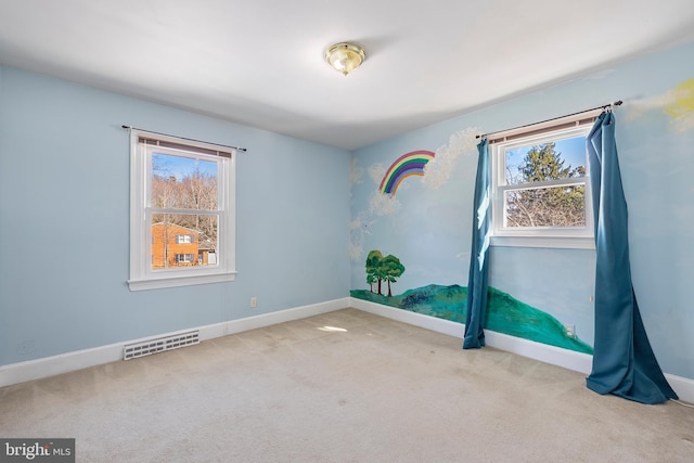 carpeted spare room featuring a wealth of natural light