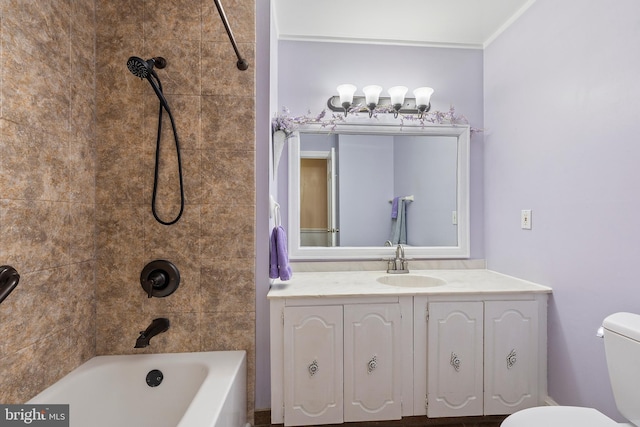 full bathroom featuring vanity, tiled shower / bath, and toilet