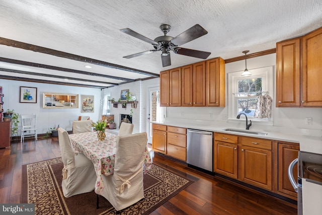 kitchen featuring sink, dark wood-type flooring, hanging light fixtures, a textured ceiling, and stainless steel dishwasher