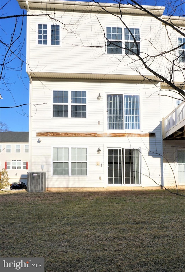 back of house with central AC and a yard