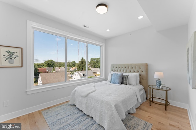 bedroom featuring multiple windows and light hardwood / wood-style flooring