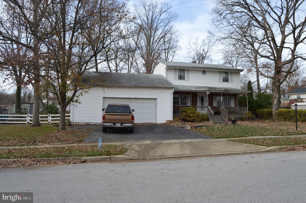 view of front facade featuring a front yard, covered porch, and a garage