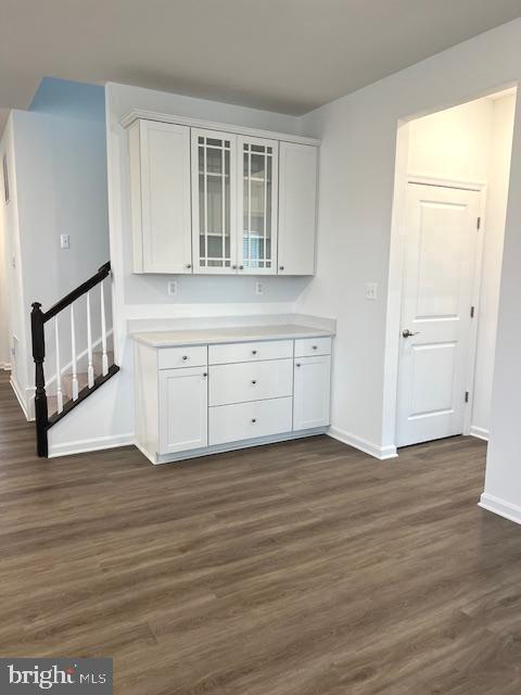 kitchen with dark wood-type flooring and white cabinetry