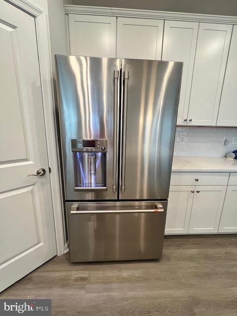 kitchen featuring light hardwood / wood-style flooring, white cabinets, tasteful backsplash, and high quality fridge