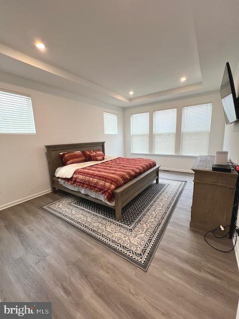 bedroom featuring dark hardwood / wood-style floors and a raised ceiling