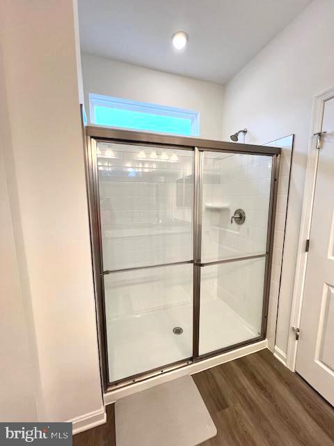 bathroom featuring hardwood / wood-style floors and walk in shower