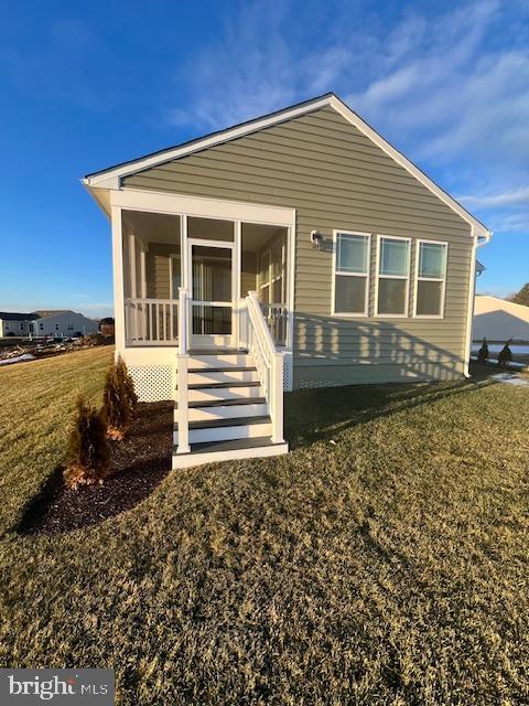 view of front of property featuring a front yard and a sunroom