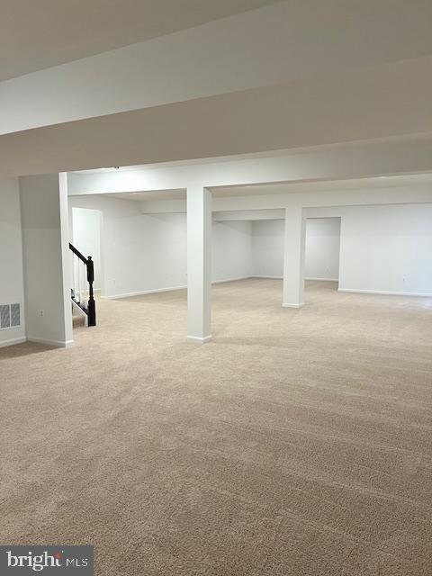 basement featuring light colored carpet