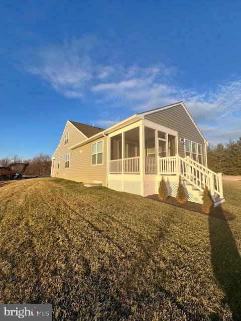 exterior space featuring a front lawn and a sunroom