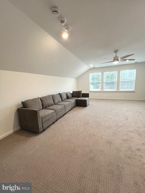 unfurnished living room with light carpet, ceiling fan, and lofted ceiling