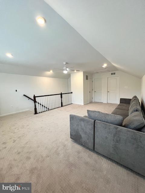 living room with ceiling fan, lofted ceiling, and carpet flooring