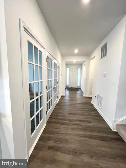 corridor with dark hardwood / wood-style flooring