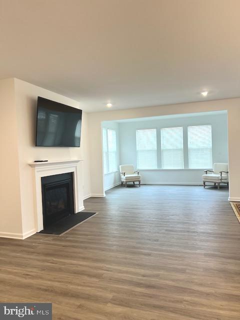 unfurnished living room with dark hardwood / wood-style flooring and a wealth of natural light