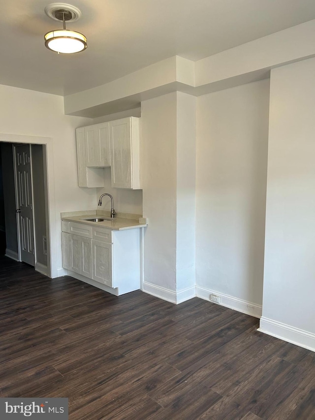 kitchen featuring sink, dark wood-type flooring, and white cabinetry