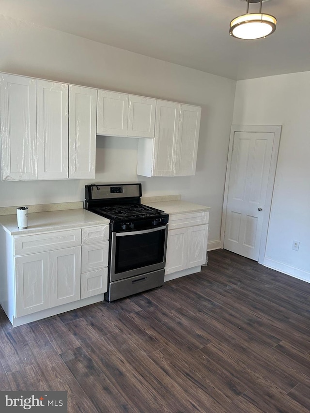 kitchen featuring dark hardwood / wood-style flooring, white cabinets, and gas range