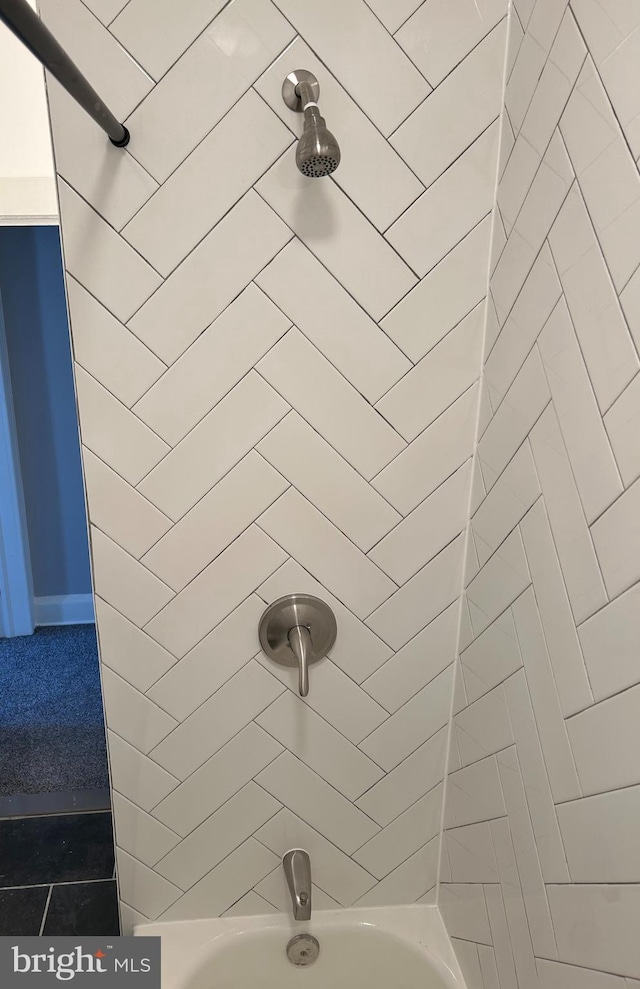 interior details featuring tiled shower / bath combo