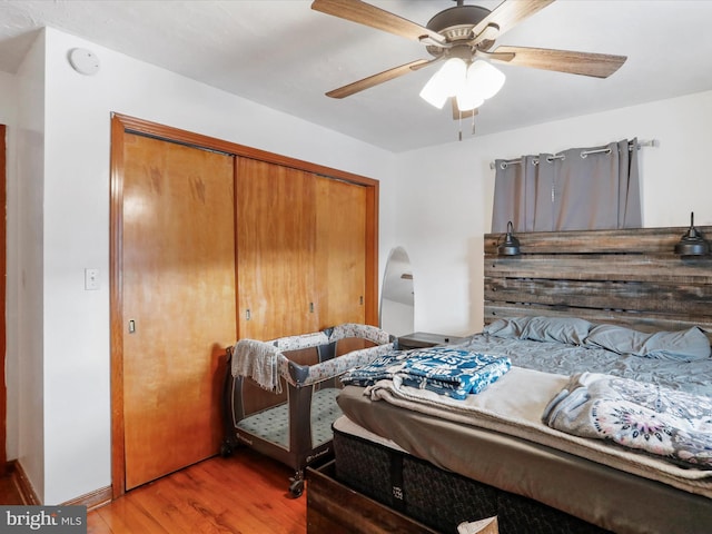 bedroom with ceiling fan, a closet, and wood-type flooring