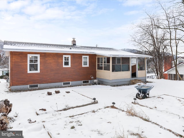 view of snow covered rear of property