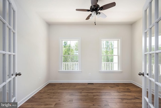 empty room with french doors, dark hardwood / wood-style floors, and plenty of natural light