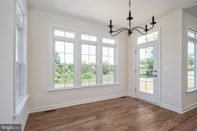 entryway with a healthy amount of sunlight, dark hardwood / wood-style flooring, and a chandelier