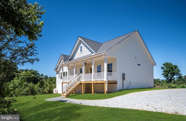 back of house with a lawn and covered porch