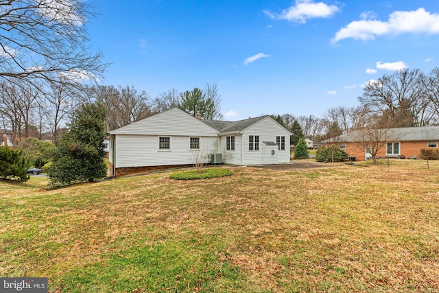 rear view of property with a yard and central AC