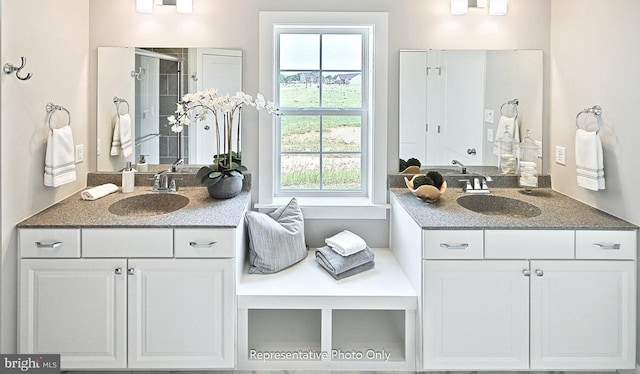 bathroom with a shower with shower door and vanity